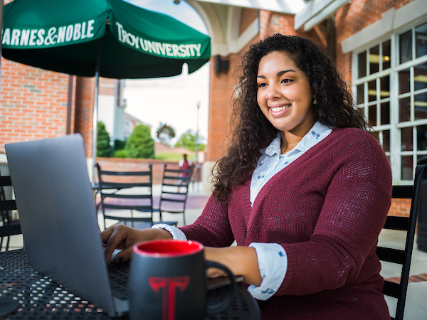 Female student working on a computer outside