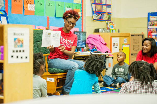 student reading a book to class