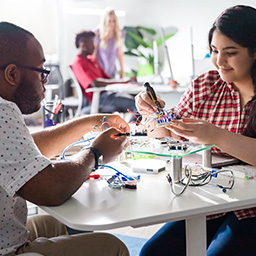 TROY students working with electrical components.