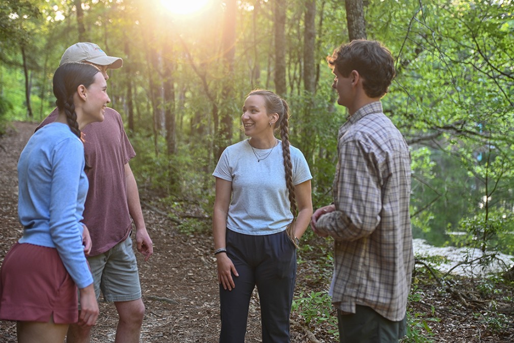 Troy University students talking on a trail in the Arboretum