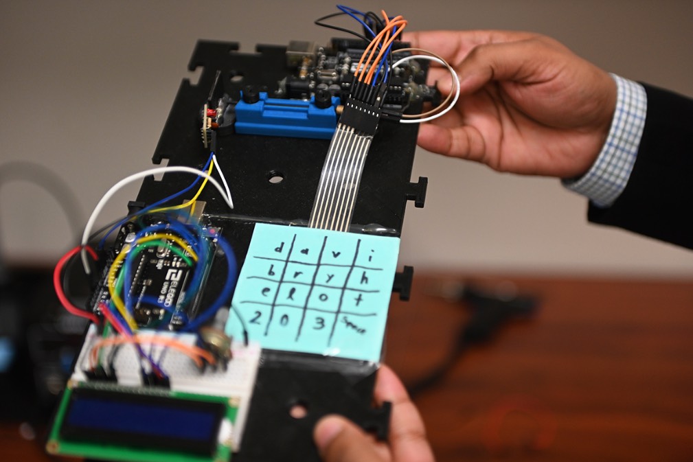 A professor shows a constructed calculator.