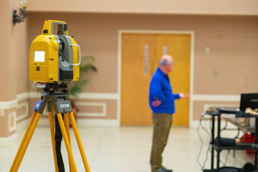 Professional discusses surveying with an electronic/optical instrument used for surveying and building construction on display during a Geo Day session