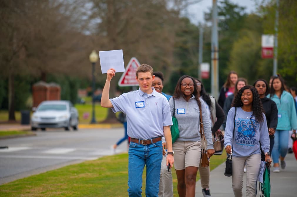 Troy University geomatics student leads high school student to a Geo Day session