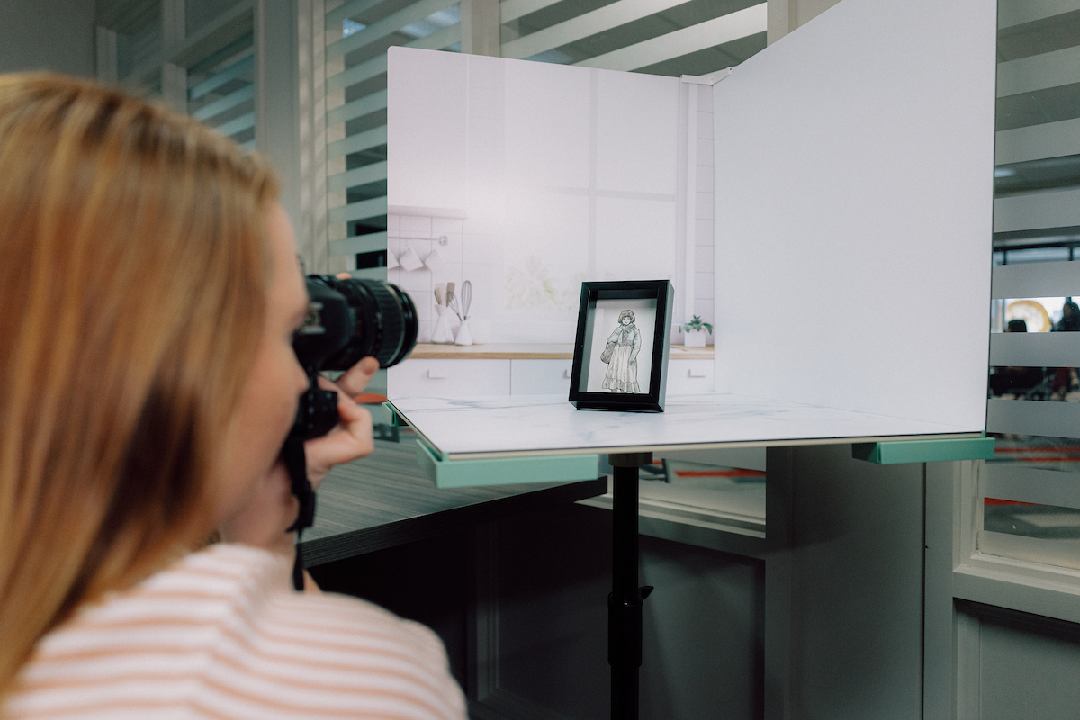 Student taking photos of the product she created for Student Made store