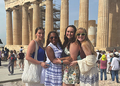 TROY students enjoying study abroad in historic Greece and posing in front of ancient columns
