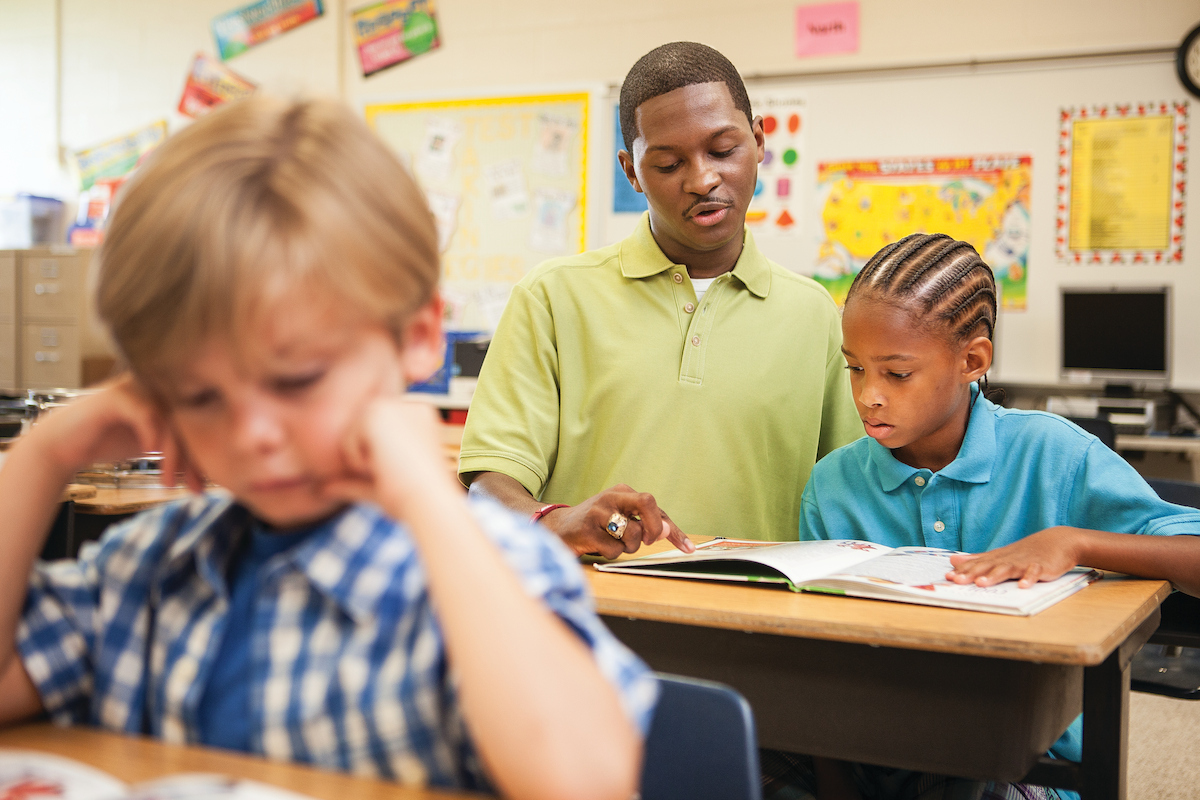 Teacher assisting student