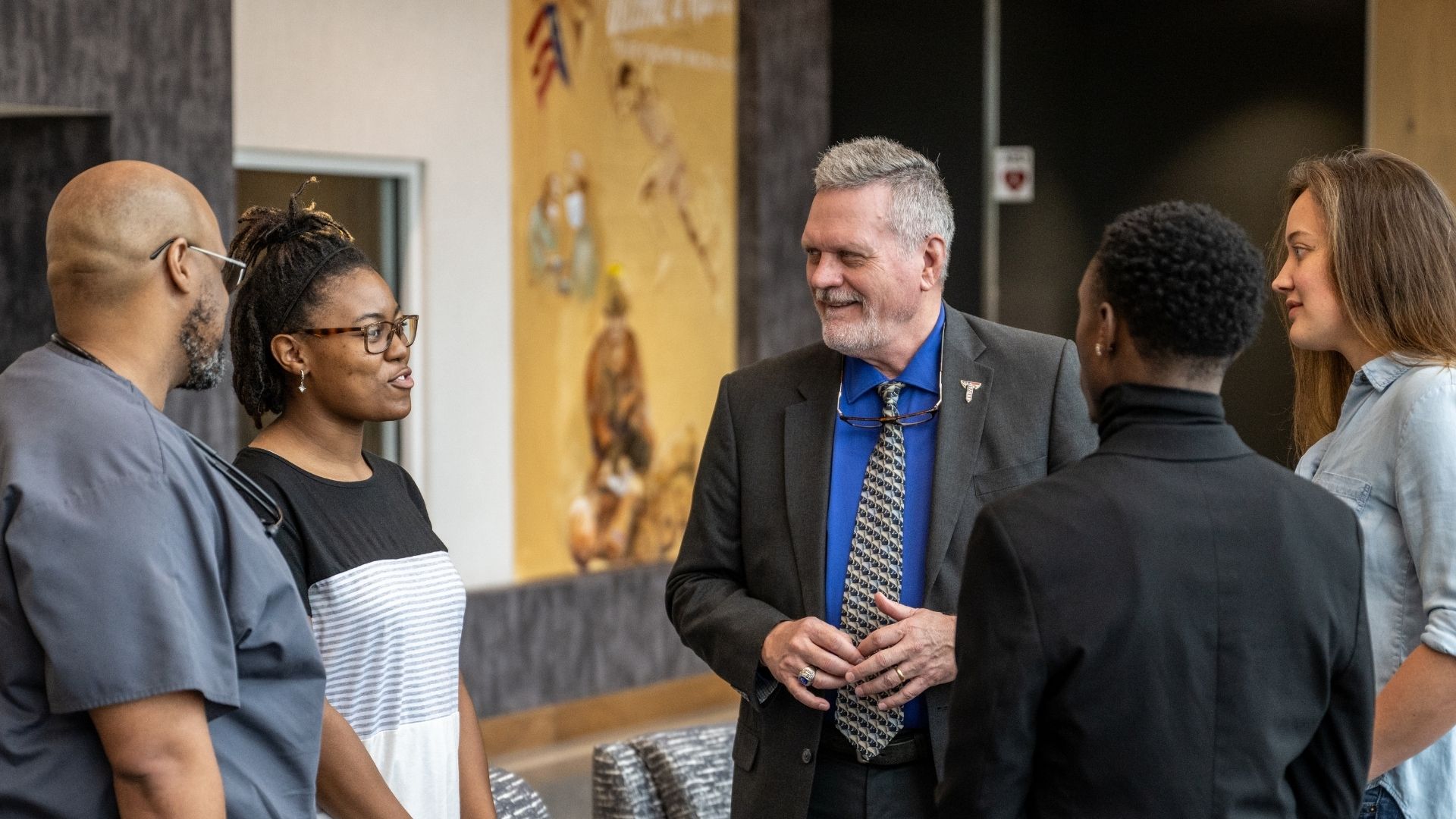 Dr. Carter talking with health sciences students in the lobby of Jones Hall