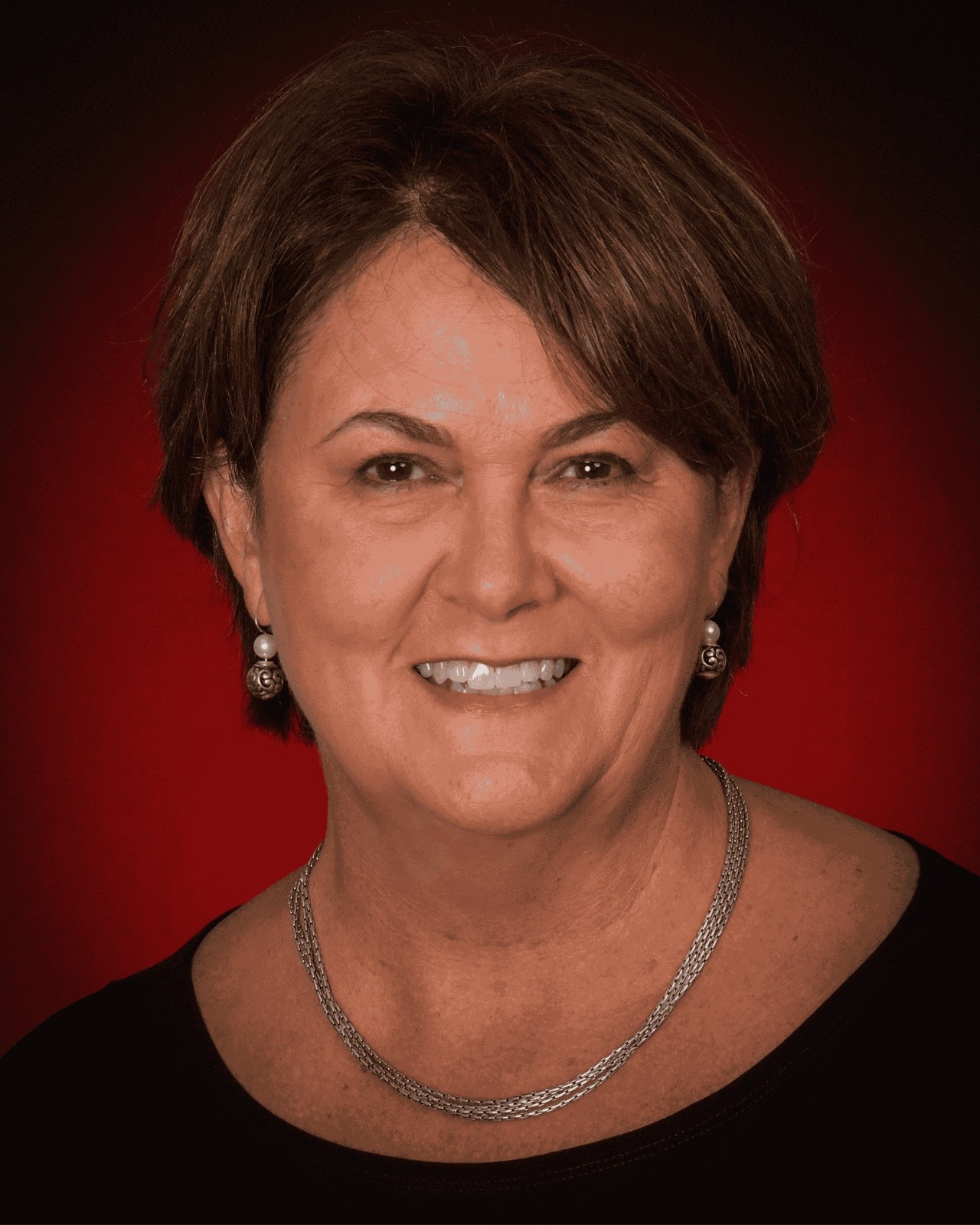 Sally Gomez headshot with a red background