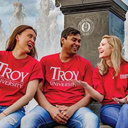 TROY graduate students happily chatting at the on campus quad fountain.