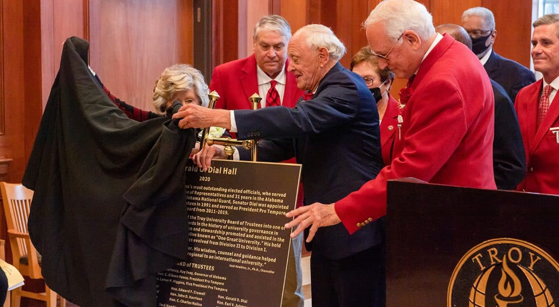 President Pro-tem Emeritus Gerald O. Dial, right, and his wife Faye unveil a plaque dedicating the Trojan Village 400 building as Gerald O. Dial Hall with Chancellor Dr. Jack Hawkins, Jr. and the University Board of Trustees.