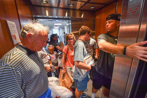 Members of the Troy Trojans Football Team pitch in to help new students moving into the dorms on Saturday.