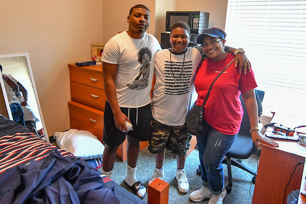 Freshman Jarrod Alexander from Newnan, GA poses with mom, Jennifer and his brother Jacob as he settles in to his new room.