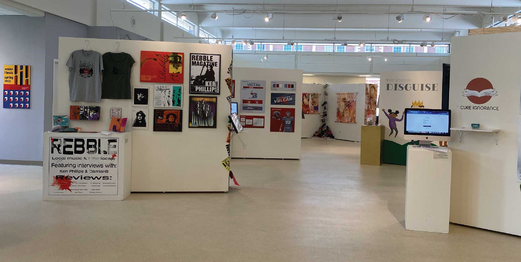 Multiple walls of thesis displays. One shows book covers and the other shows off a brand of music.