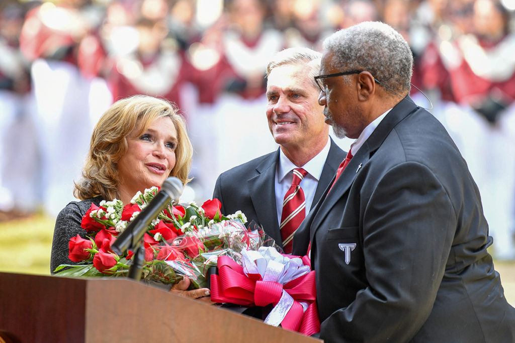 Gibson Vance, President pro-tempore of the Troy University Board of Trustees, and Lamar P. Higgins, Vice President pro-tempore, present TROY First Lady Janice Hawkins with a bouquet of roses during the ceremony.