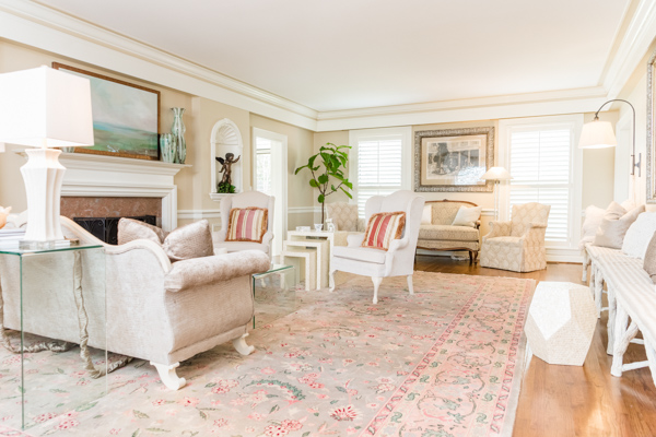 Inside the formal living room of the Chancellor’s residence hosts an array of seating that includes two couches, four chairs, a love seat and wooden bench, all with a view of the fireplace. 