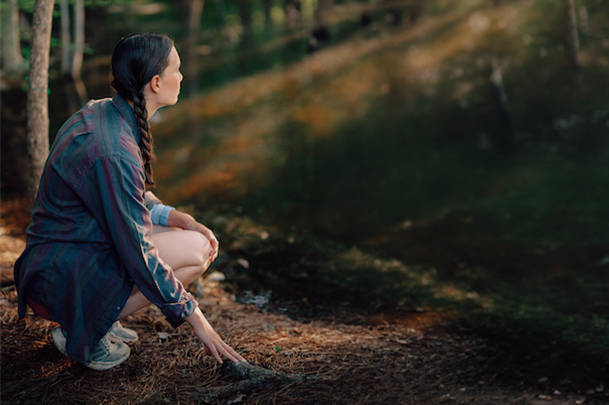 Student at the arboretum looking into the distance