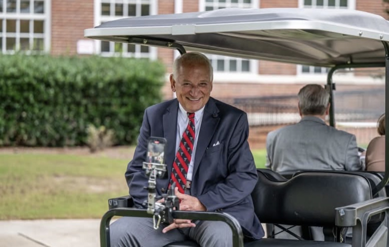 Dr. Jack Hawkins on the back of a golf cart recording a Cart Jacked Video Series