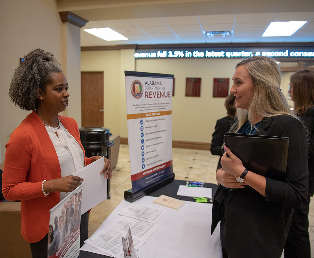 Student and professional at a job fair.