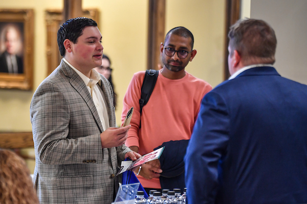 Students dressed in business attire, talking to people at career fair.