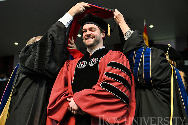 Global Leadership Graduate during commencement being hooded