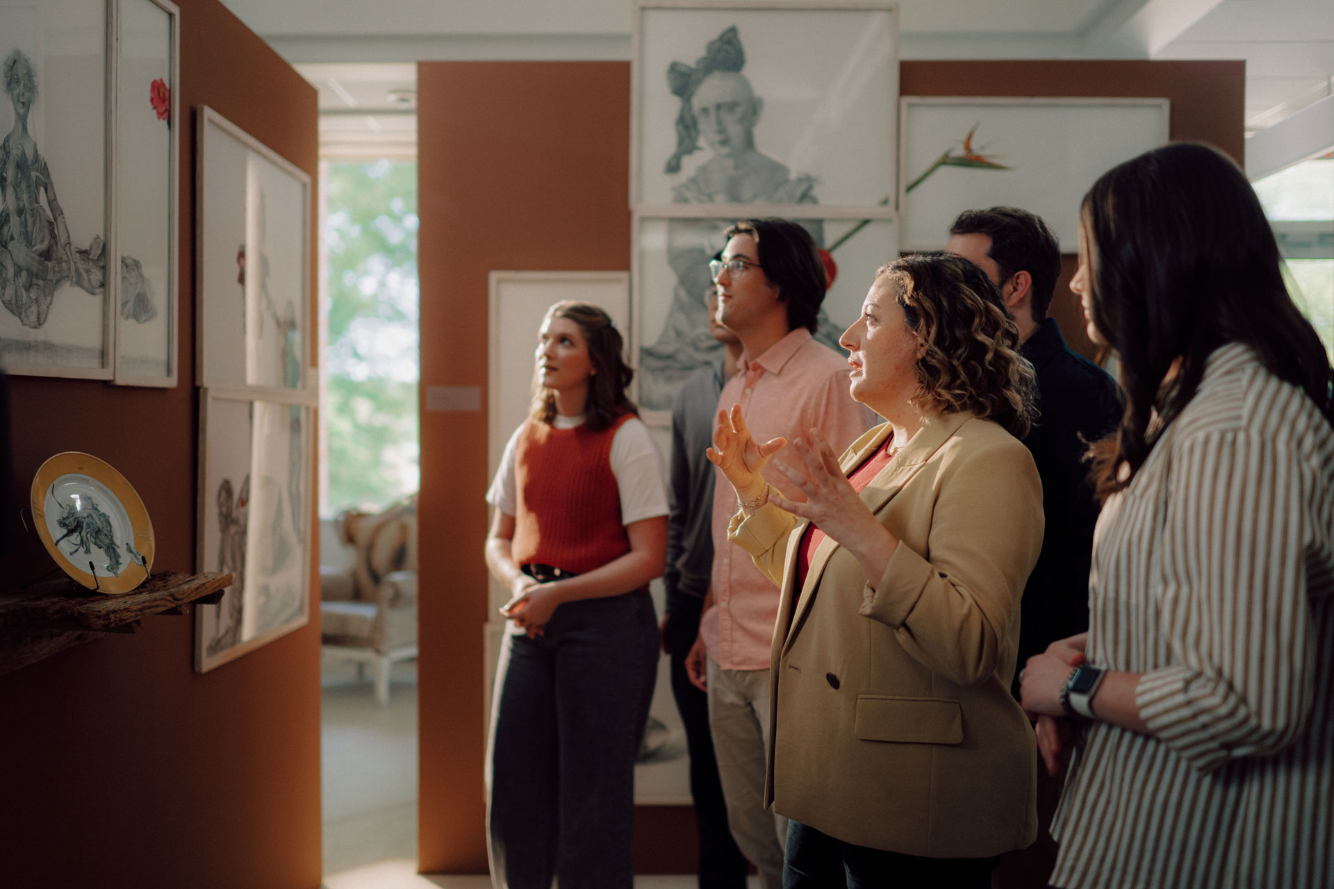 A TROY art and design professor discusses artwork with her students in the Nall Museum and Gallery.