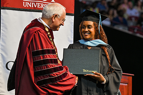 TROY graduate receiving their diploma at commencement.