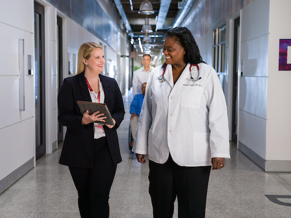 Nurse and administrator walking down hall of hospital 