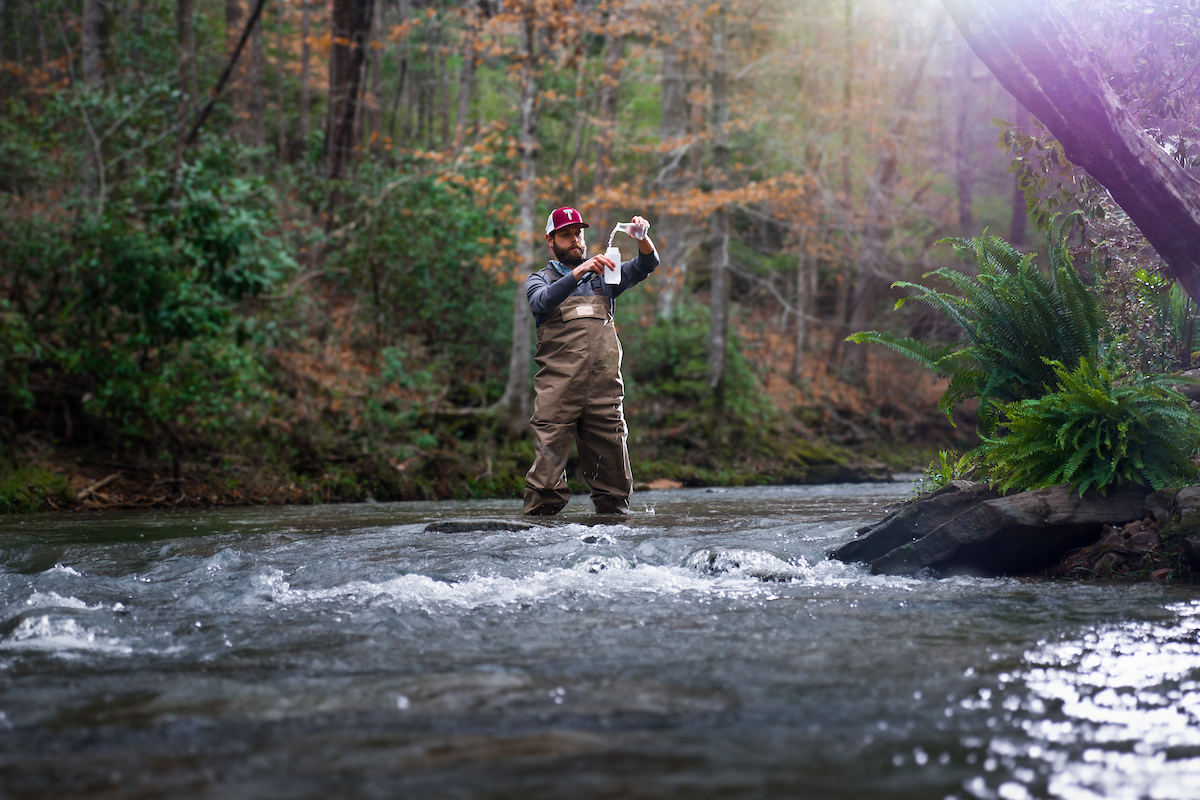 TROY alumni testing water samples in the field.