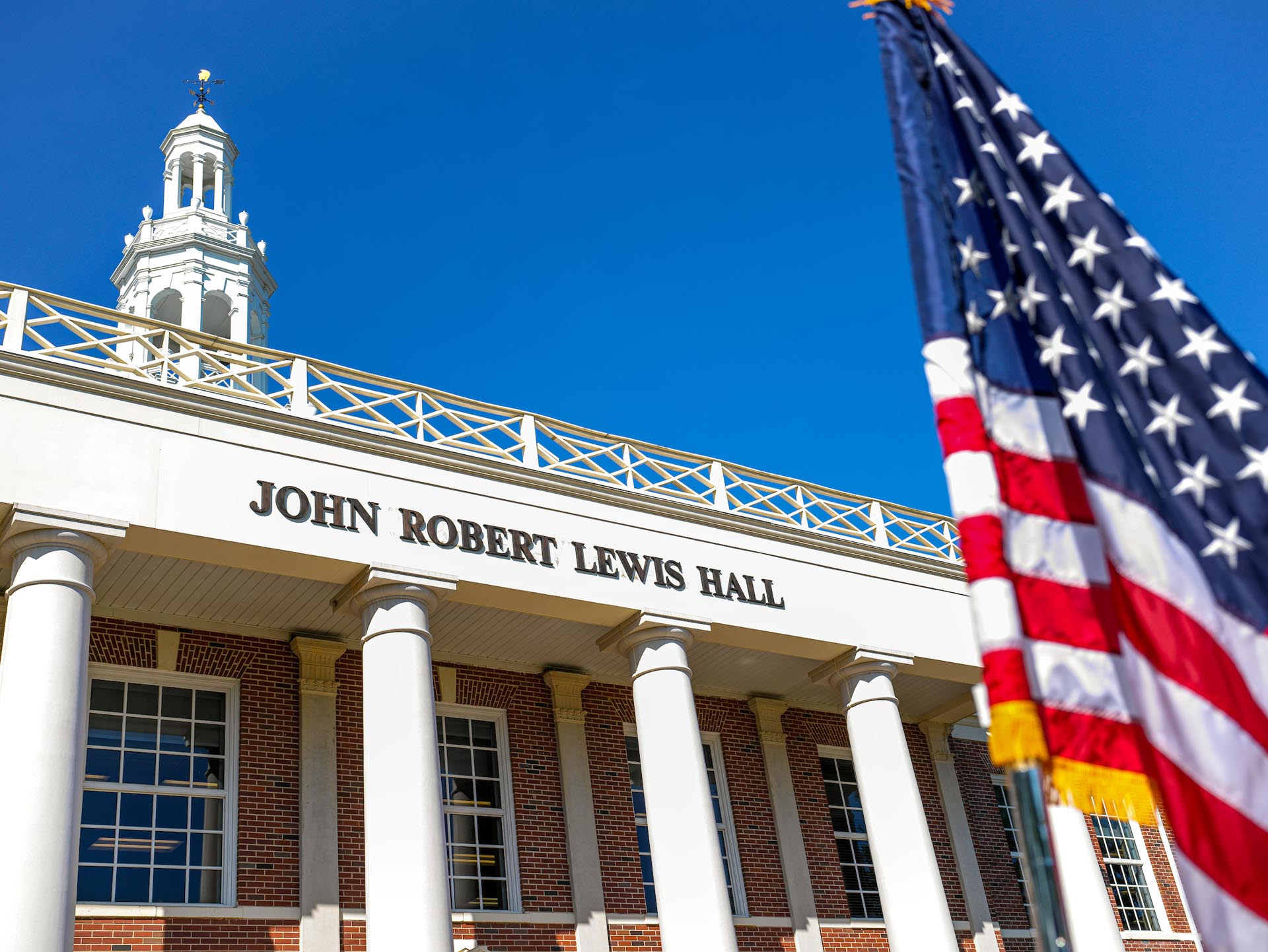 Photo of an American flag in front of John Lewis Hall