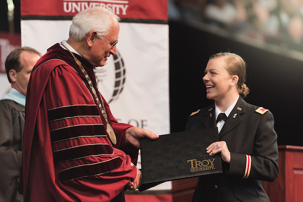 Military graduate receiving her degree at commencement.