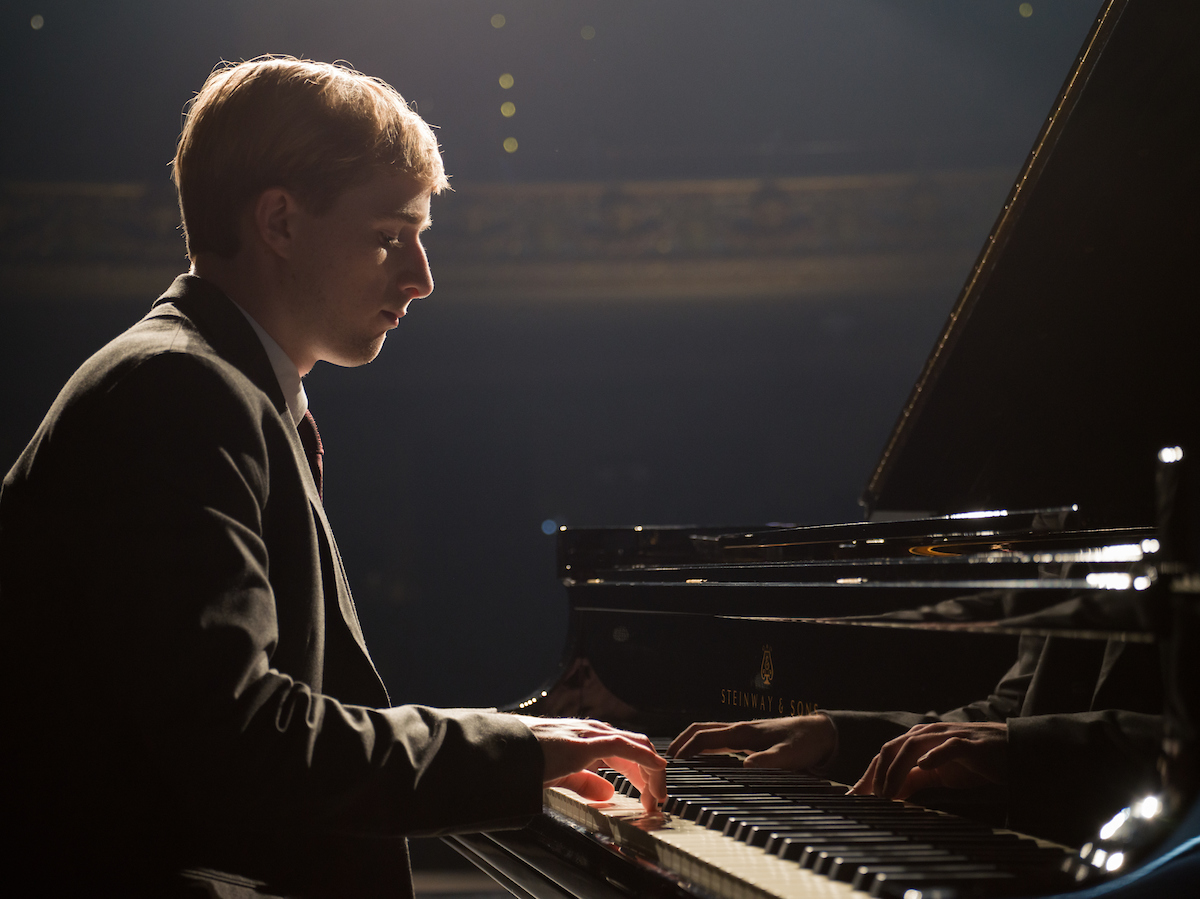 TROY student playing a piano.