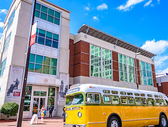 Image of the rosa parks musuem with the yellow bus boycott replica infront of it