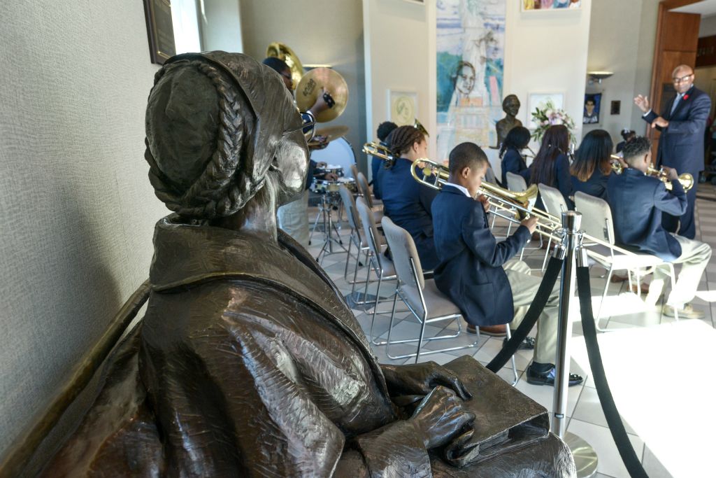 Rosa PArks statue in foreground and students playing instruments in background