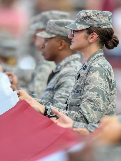 Military personnel holding a flag.