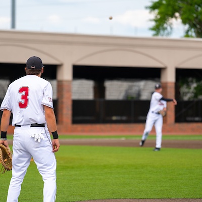 Baseball players are throwing a ball on the field.