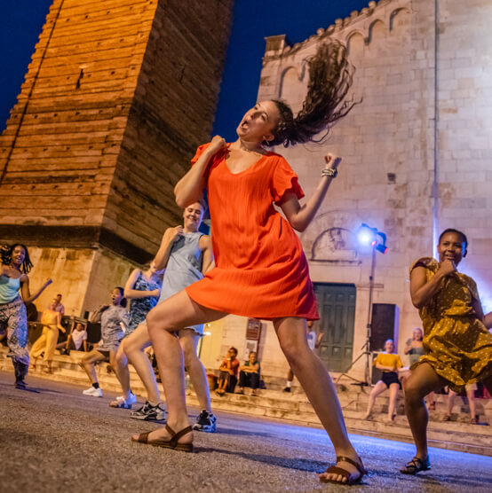 Students dancing in public square while studying abroad in Italy.