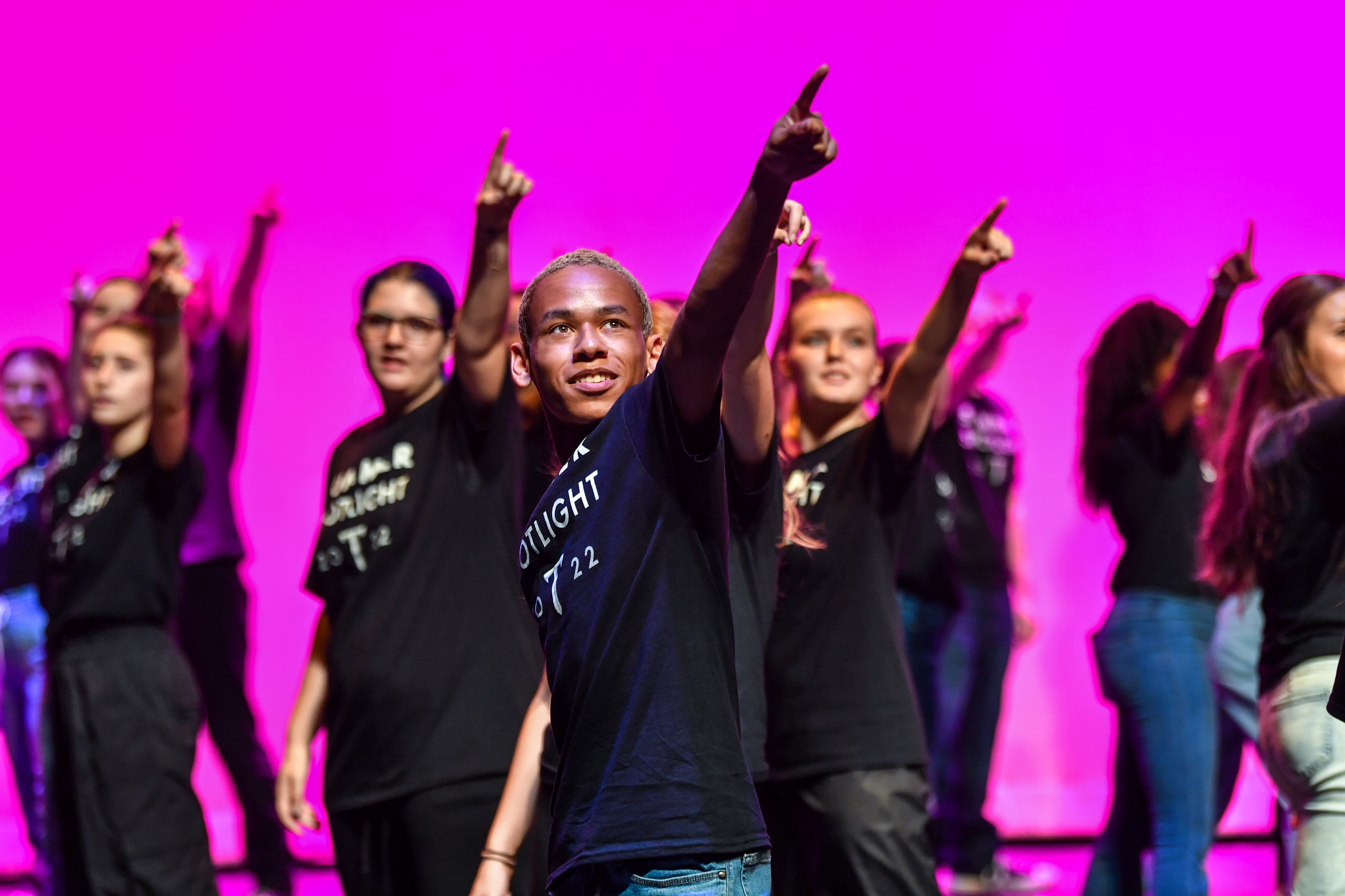 performers on stage pointing