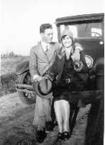 [1920s]  Henry Smith with female friend sitting on bumper of Ford Model T.