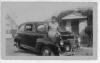 Aunt Mamie Sue Martin (Annie Jane Martin's daughter), taken at grandmother's house, 115 Hall St., Abbeville, AL. Woman sitting on fender of 1940s automobile, coupe, possibly Pontiac, house in background. Ca. 1940.