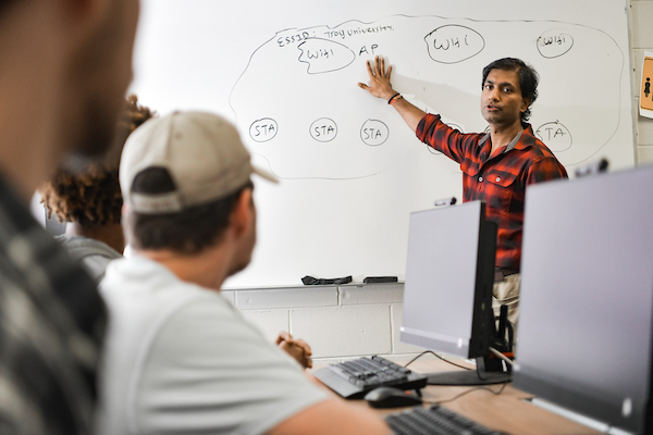 students listening to teacher in a computer science class